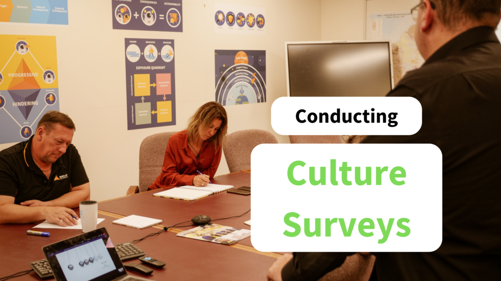 Two people write on paper. Text on image says: conducting culture surveys